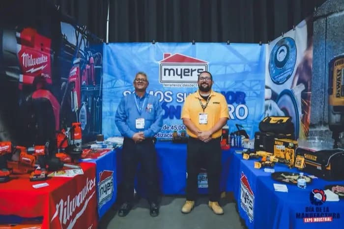 Personal de un stand de bombas y equipo hidráulico atendiendo visitantes.